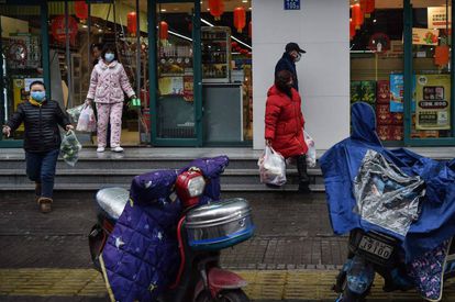 People wearing face masks leave after stocking up on food at a market in Wuhan on January 26.