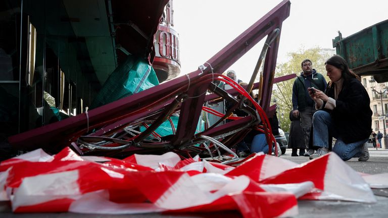 Sails of the landmark red windmill atop the Moulin Rouge, Paris' most famous cabaret club, are seen on the ground after a fall off during the night in Paris, France, April 25, 2024. REUTERS/Benoit Tessier 