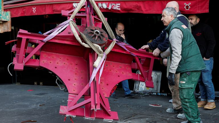 Sails of the landmark red windmill atop the Moulin Rouge, Paris' most famous cabaret club, are seen on the ground after a fall off during the night in Paris, France, April 25, 2024. REUTERS/Benoit Tessier 