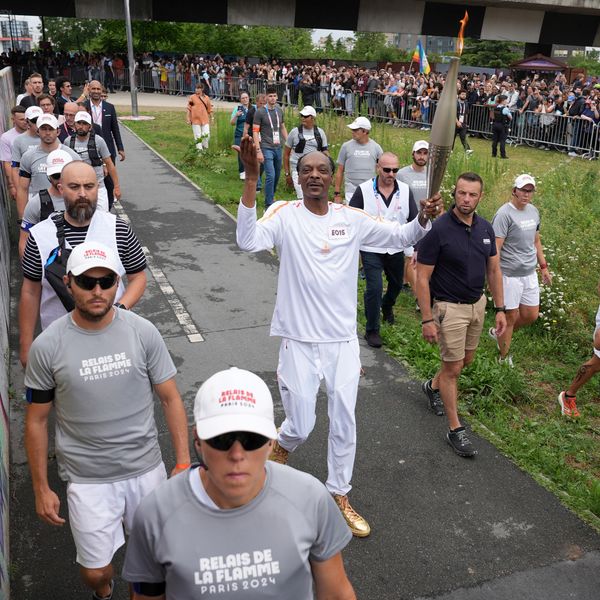 26 July 2024, France, Paris: Before the Summer Olympics, Paris 2024 Olympics, torch relay. US rapper Snoop Dogg carries the torch during the torch relay. Photo by: Marcus Brandt/picture-alliance/dpa/AP Images